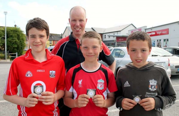 Pictured this evening with one of their dedicated Mentors, John Cashman - we just happened to meet three talented members of the Millstreet Team who had just received their medals having reached the Final in the Rebel Óg 2014 Football Competition.  From left:  Dylan Kelleher, Darragh Cashman and Omar Daly.  Sincere congratulations to the excellent young sports people.  Click on the images to enlarge.  (S.R.)