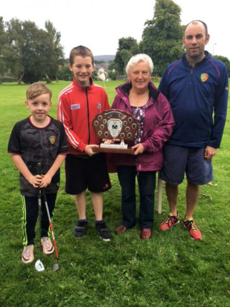 Mary O Connor presenting the Alan O'Connor Memorial Trophy to Simon Murphy. Included are her son Colm and grandson Cian